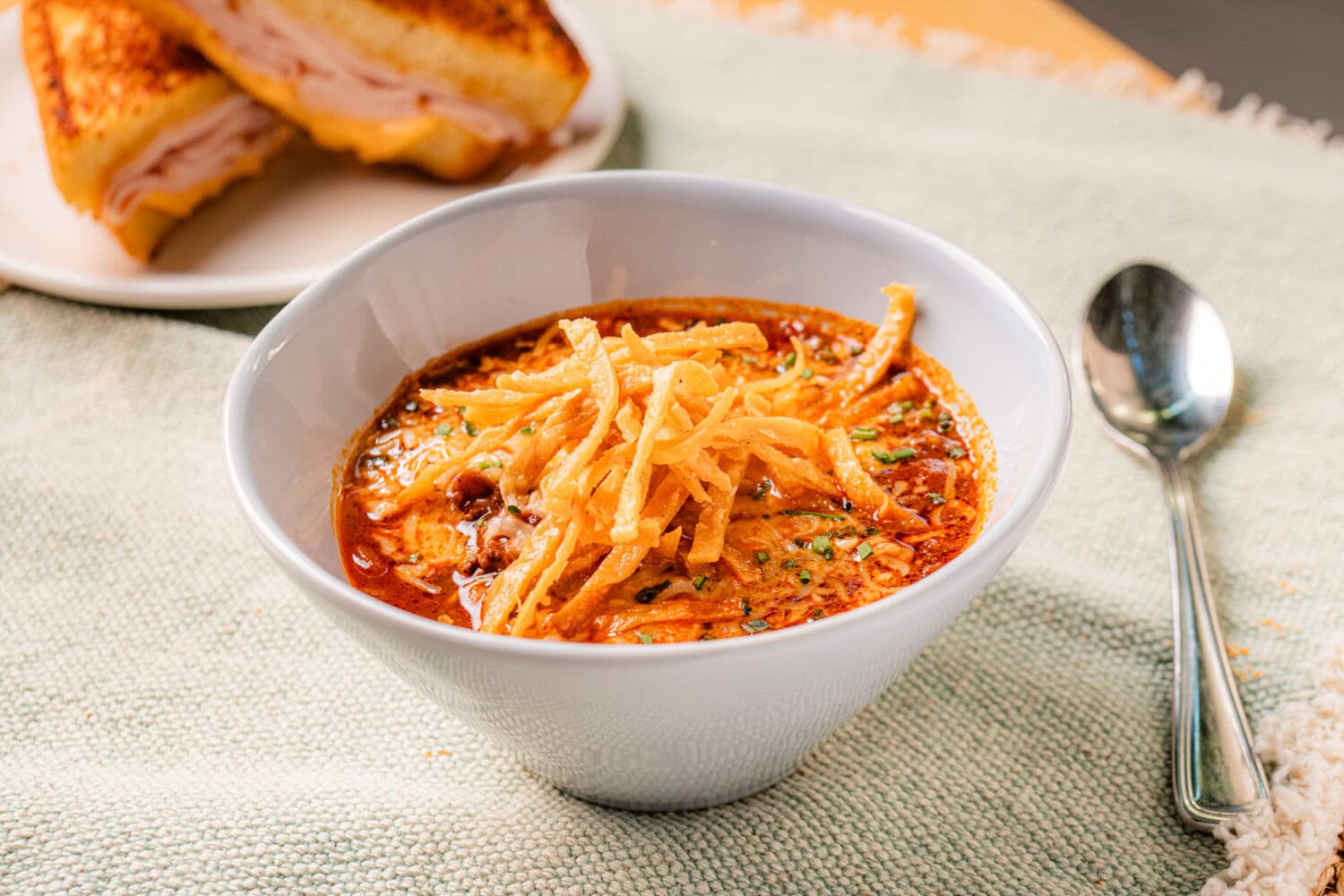 Bowl of chili topped with shredded cheddar cheese